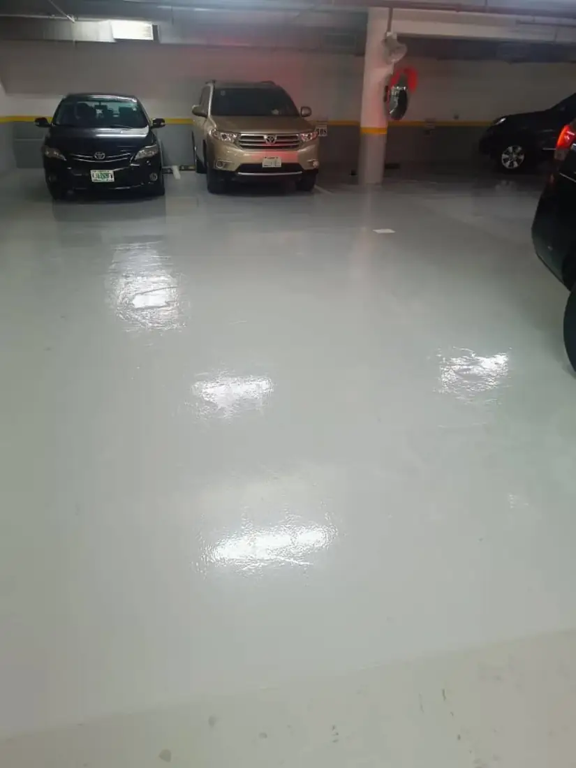 Gloss white epoxy car park floor with parked vehicles in Awka